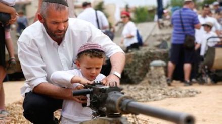 Israeli adult teaches a child how to use a gun