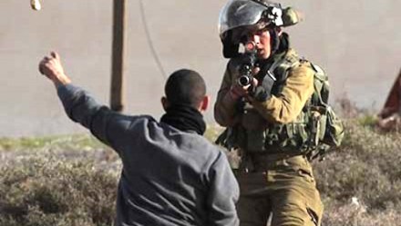Israeli soldier points gun at child