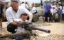 Israeli man shows his son how to fire a machine gun
