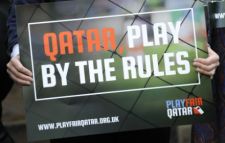 Person holding placard saying Qatar Play Fair