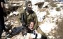 Israeli soldier headlocking Palestinian boy